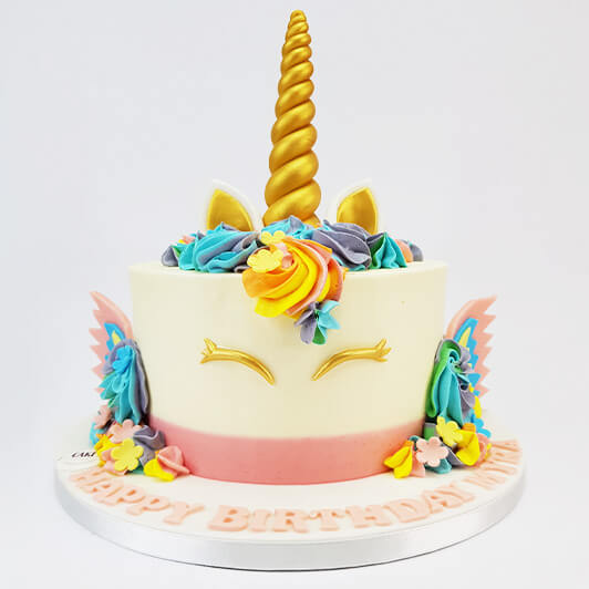 Bright and colorful unicorn cake with golden horn and ears, rainbow wings,  roses and whipped cream decor. Grey background Stock Photo - Alamy